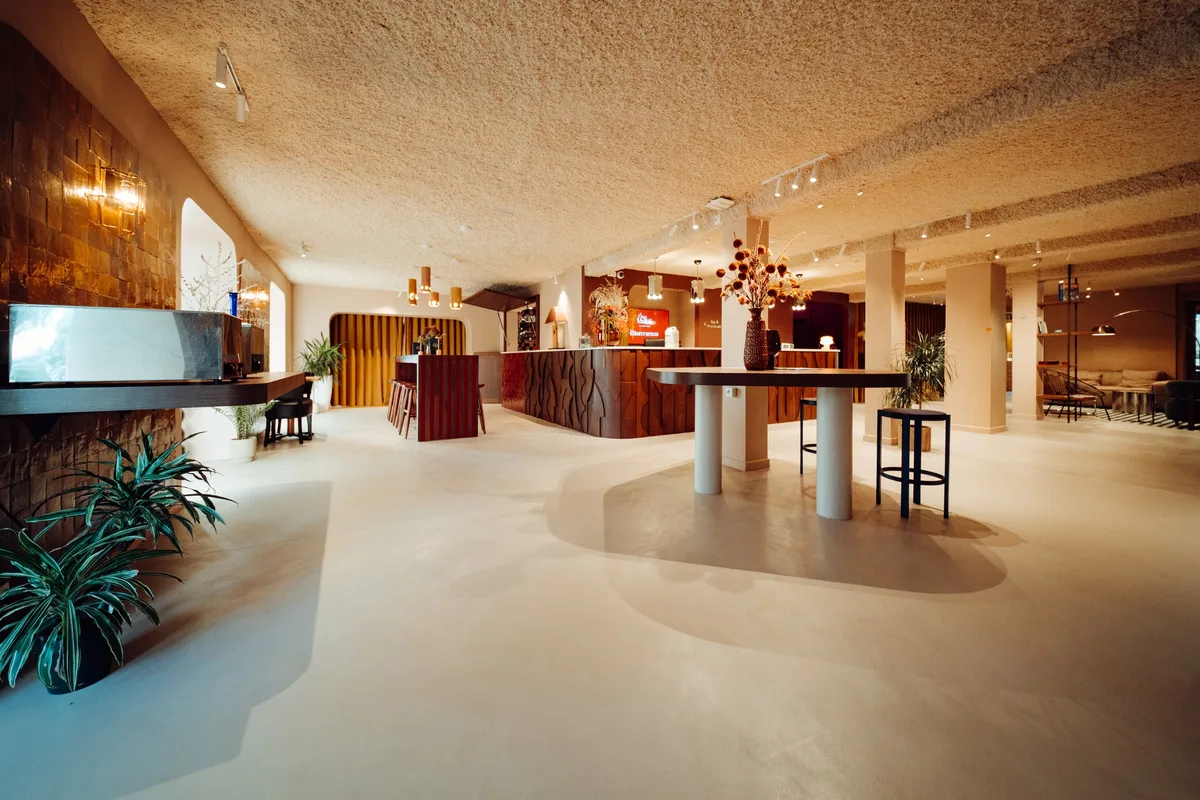 Perspective sur l’accueil et le bar de la Maison Melba : béton ciré clair sans joints