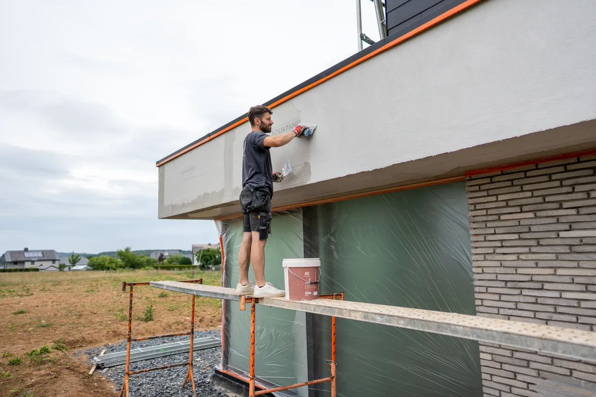 Un artisan BOW Design applique un enduit sur un chantier de maison neuve