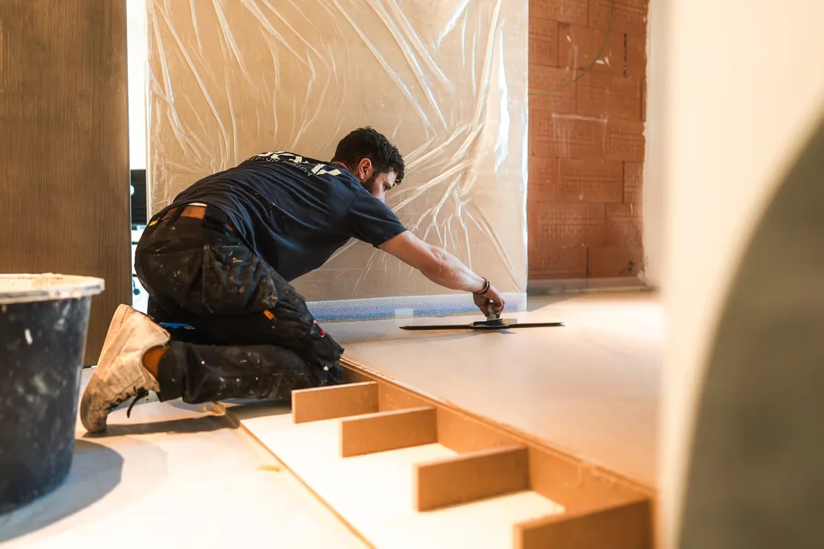 Un artisan BOW Design lisse une marche en béton ciré